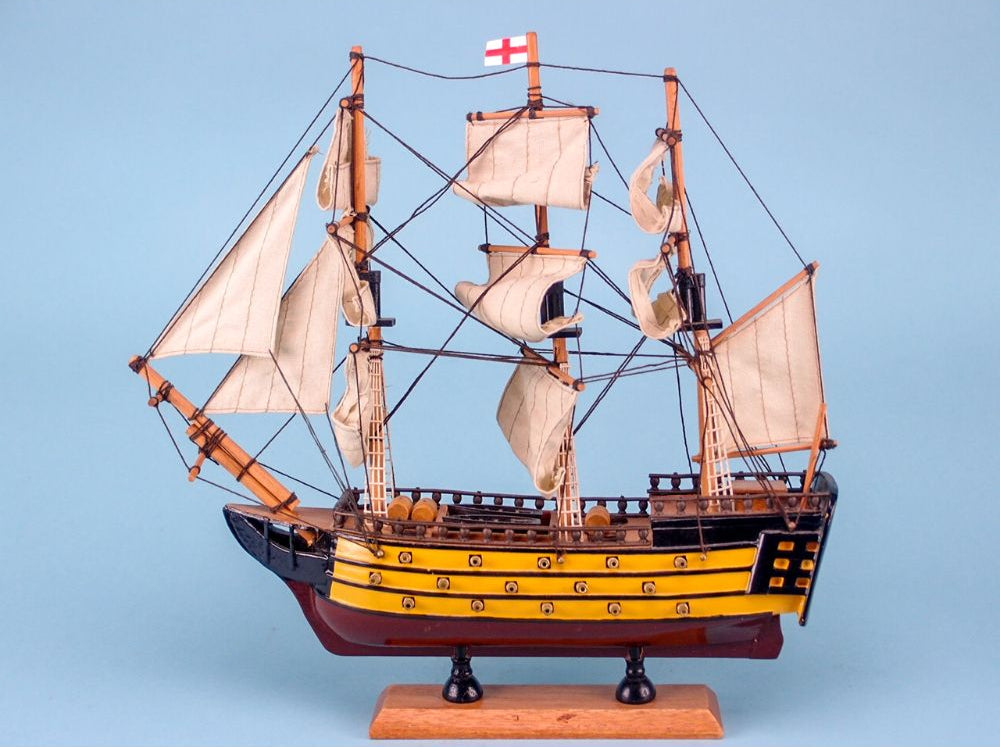 A model of the HMS Victory ship with a red and white flag, featuring multiple decks and sails.