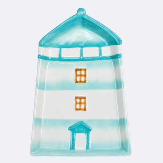 A ceramic plate designed to resemble a lighthouse with blue and white stripes and orange windows.