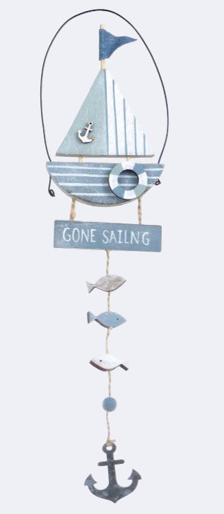 A decorative sailboat-themed wind chime with the phrase 'GONE SAILING' printed on a tag, featuring fish and an anchor below.