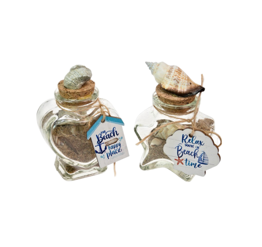 Two small glass jars with sand and shells, each labeled with a decorative tag.