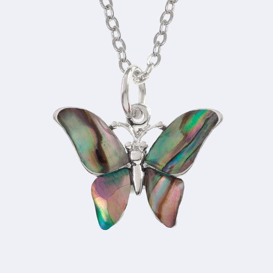 A silver-colored necklace with a natural paua shell pendant in the shape of a butterfly, displayed on a trace chain.