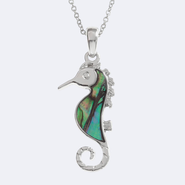 A silver-colored seahorse necklace with a natural Paua shell pendant on a trace chain, presented in a Tide Jewellery box.