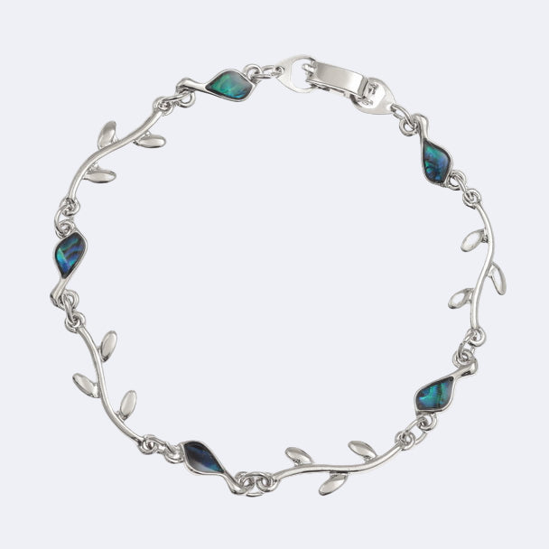 A silver-colored bracelet with blue paua shell accents, designed to resemble a bird and branch pattern.