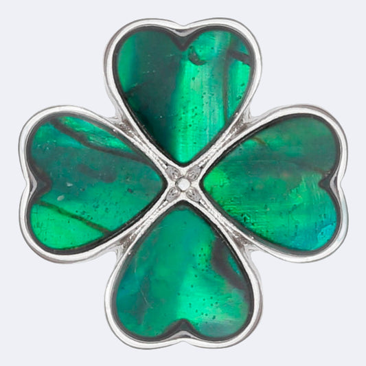 A pin badge featuring a green four leaf clover design made from Paua shell with a metal fastener.