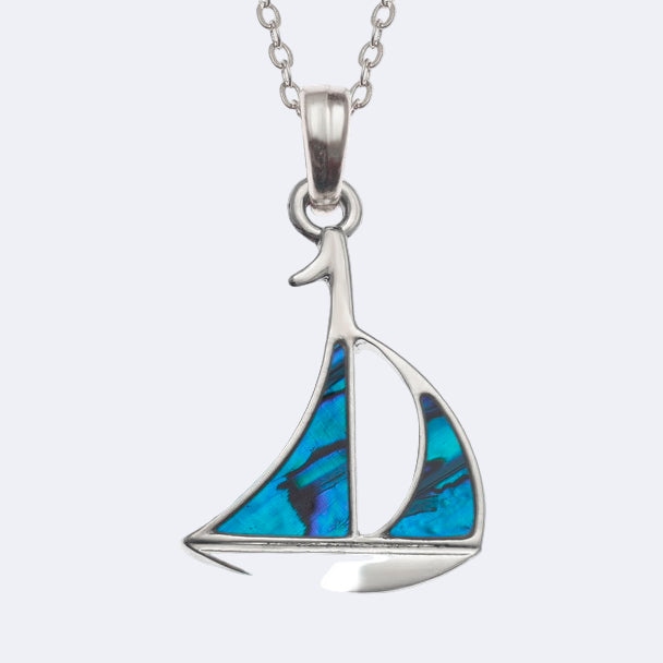 A silver-colored necklace featuring a turquoise sailboat pendant.