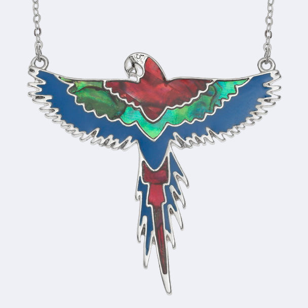 A necklace with a pendant depicting a flying red macaw, featuring Paua shell in red, green, and blue colors with blue epoxy paint, suspended on a chain.