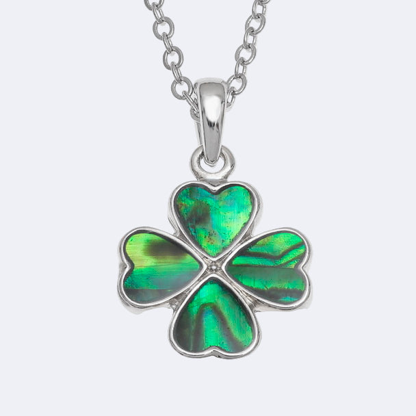 A silver necklace with a green four leaf clover pendant on a trace chain.
