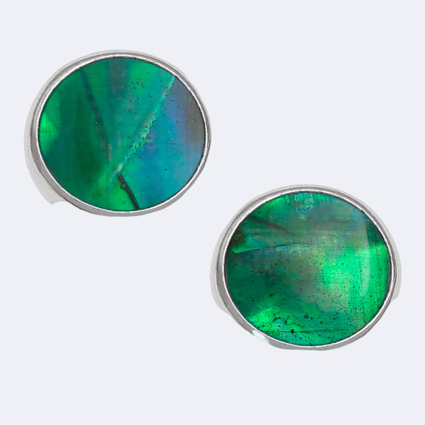 A pair of round stud earrings with green Paua shell inlay, set in a silver-colored frame.