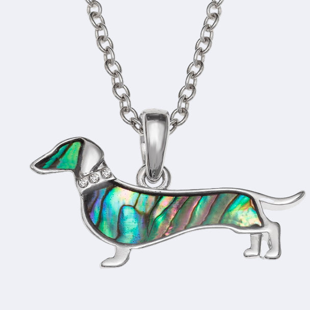 A dachshund dog necklace made of paua shell with glass stones collar on a silver trace chain.