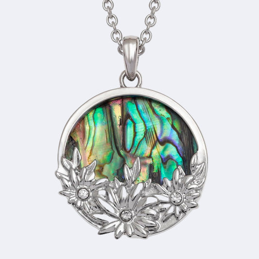 A silver-colored necklace with a round pendant featuring three flower designs and a paua shell inlay, accompanied by AB glass stones.