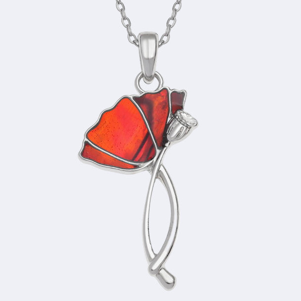 A silver-colored necklace with a red paua shell pendant in the shape of a poppy flower, displayed on a trace chain.