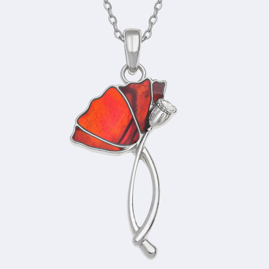 A silver-colored necklace with a red paua shell pendant in the shape of a poppy flower, displayed on a trace chain.