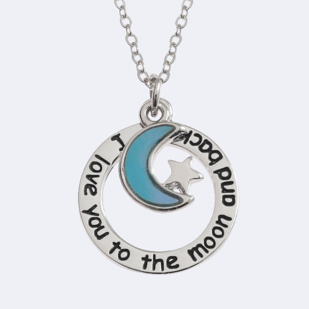 Silver necklace with a moon and star pendant and engraved text on a white background
