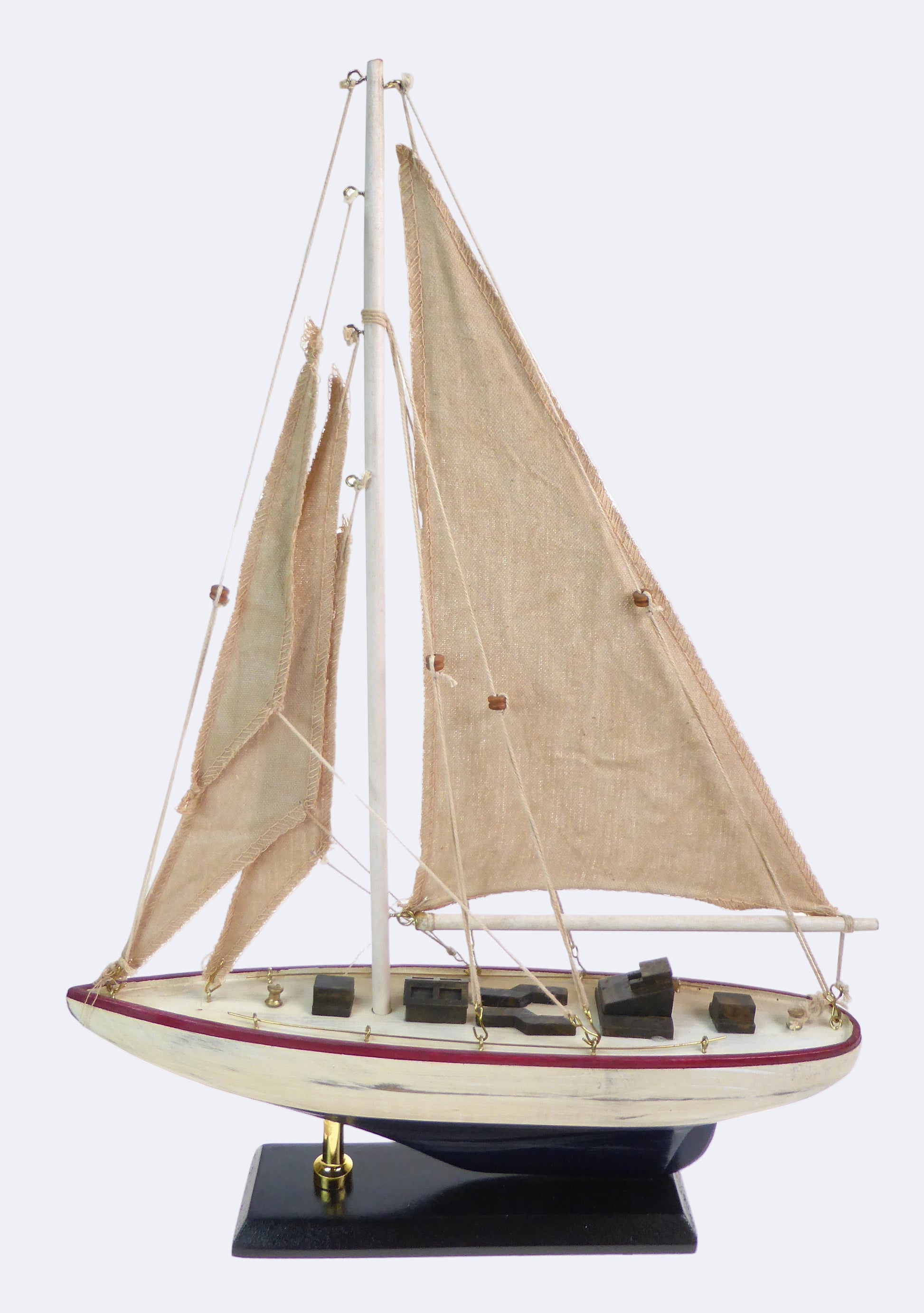 A wooden toy yacht with fabric sails, featuring a red and white color scheme on a black stand.