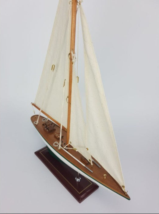 Model sailboat with white sails on a gray background