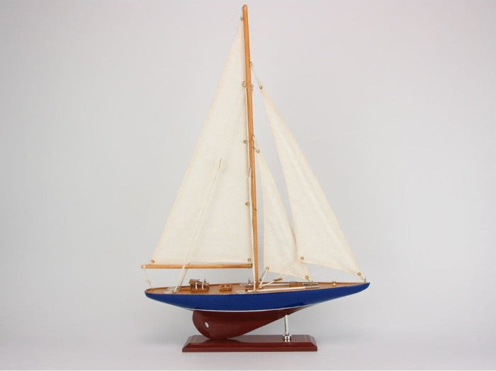 Model sailboat with white sails on a gray background
