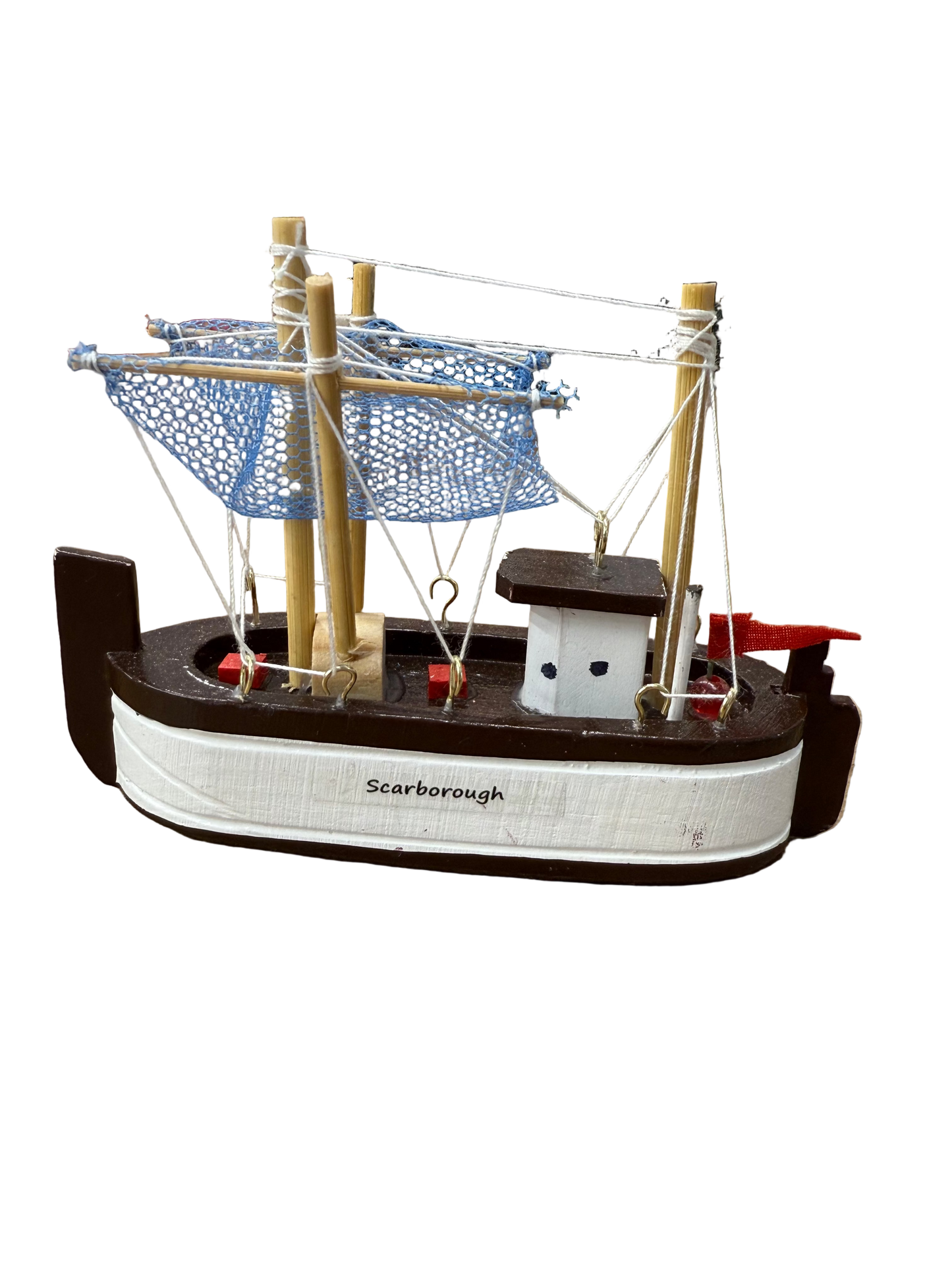Model ship with 'Scarborough' branding on a wooden surface, with a store shelf in the background.