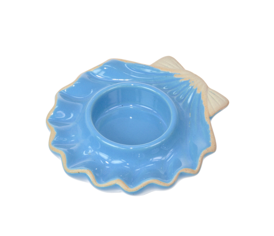 Blue ceramic dish with scalloped edge and a tealight holder in the middle on a white background