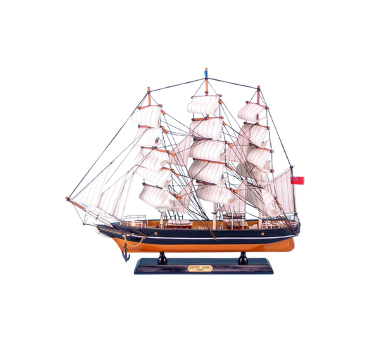 Model ship with multiple sails on a white background
