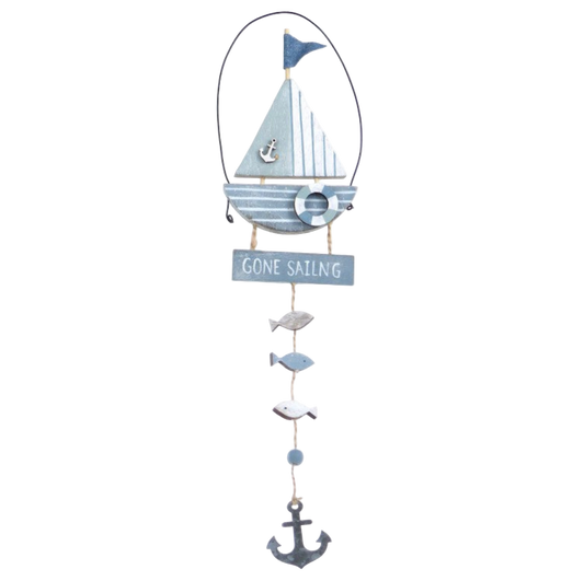 Decorative wall hanging with a sailboat, fish, and anchor on a white background