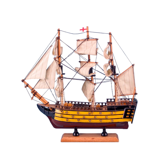 Model ship with multiple sails on a light blue background