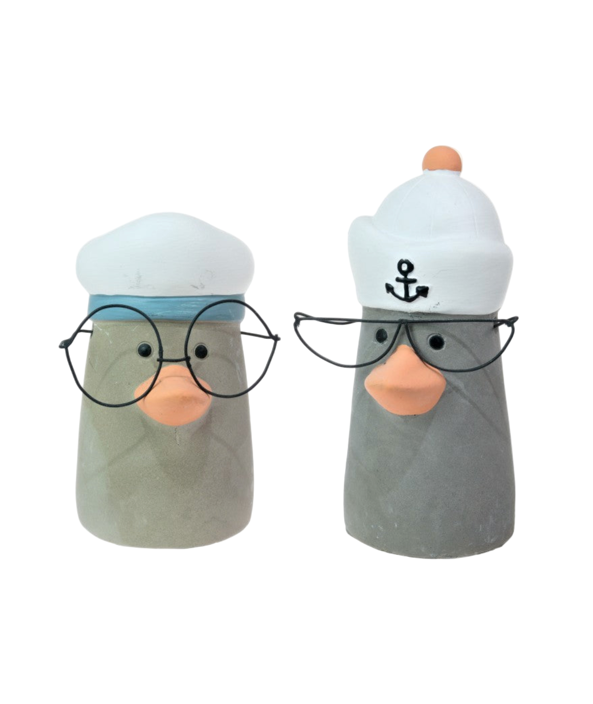 Two ceramic ducks wearing sailor hats and glasses on a white background