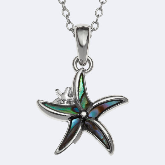 A silver-colored necklace with a natural paua shell pendant in the shape of a starfish, displayed against a white background.